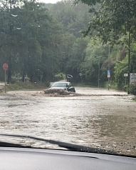Auto pflügt durch Wasser auf der Straße