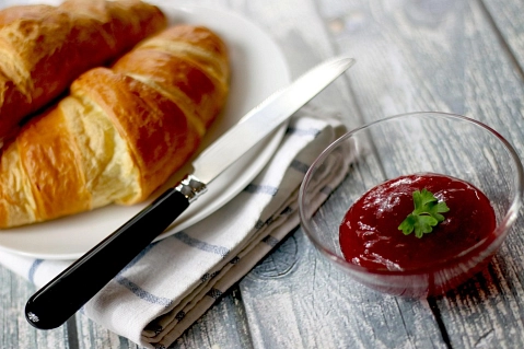 Teller mit Croissant und Marmelade