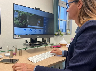 Neue Homepage_quer.jpg Imke Heymann vor PC mit neuer Homepage (Bild im Querformat)