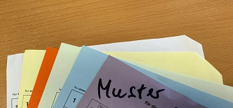 Stimmzettel_Kommunalwahl_2025.jpg Verschiedene farbige Stimmzettel im Ausschnitt